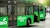 A green biogas bus pulling into a bus stop